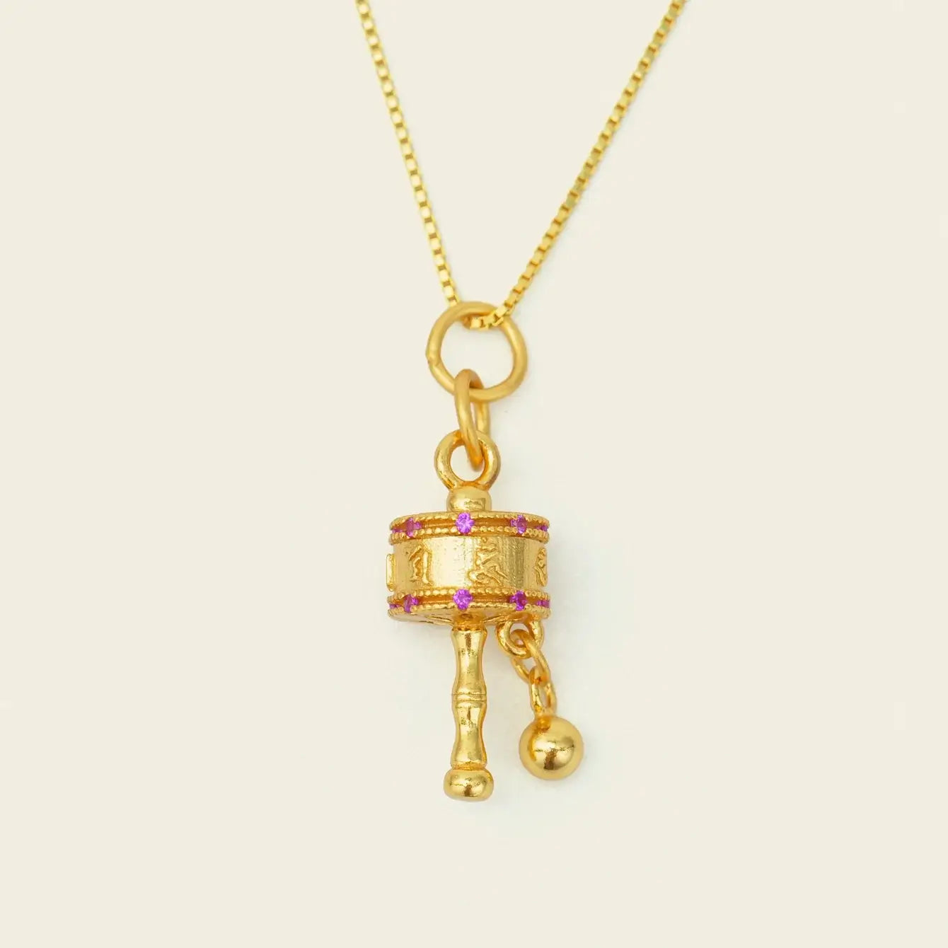 Zenify™ Mantra Wheel Necklace featuring a gold pendant with pink accents, symbolizing protection and mindfulness.