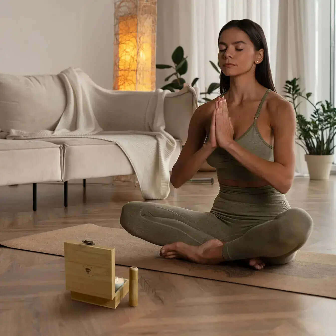 Woman meditating with Zen Positive Energy Awakening Meditation Mini Kit in a serene living room setting.