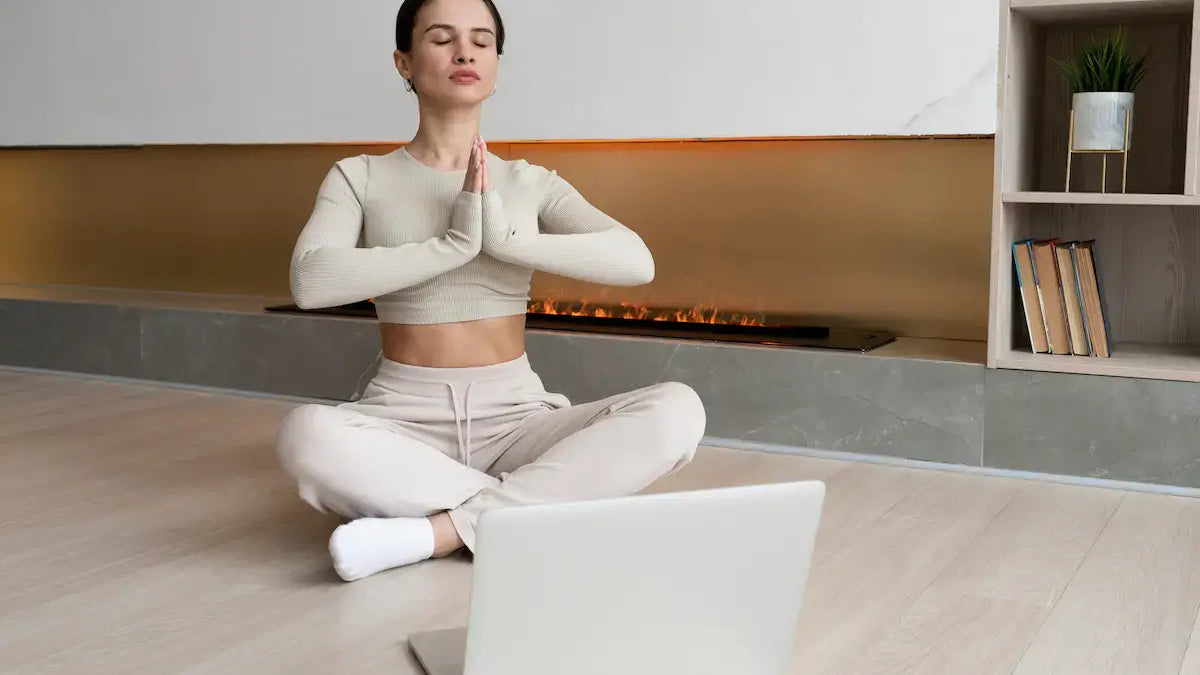 Woman practicing mindfulness while learning about why some people are more prone to stress with a laptop.