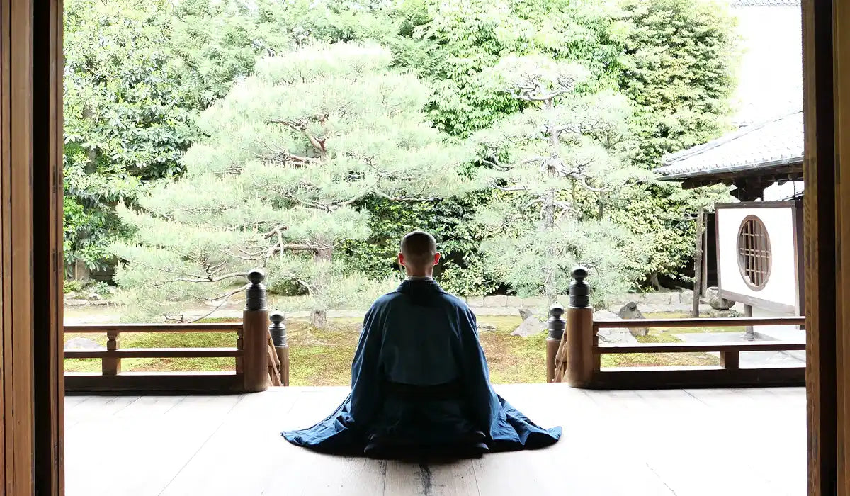 Person meditating in a serene Japanese garden, embodying the essence of 6 Japanese Mental Models That Rewire Your Brain for Calm and Clarity.