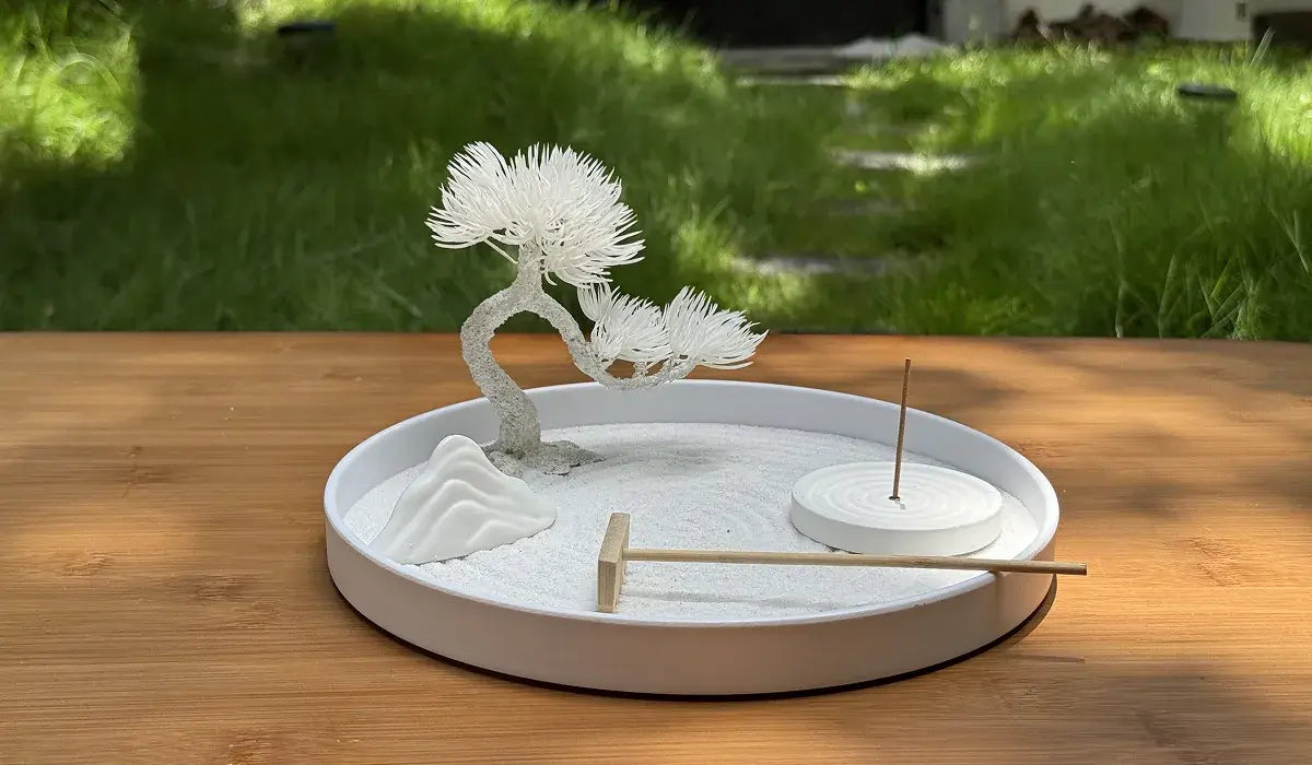 A serene Zen garden setup featuring a miniature tree, rocks, and an incense holder, illustrating 7 Zen Garden Placement Secrets and Mindfulness Practices.