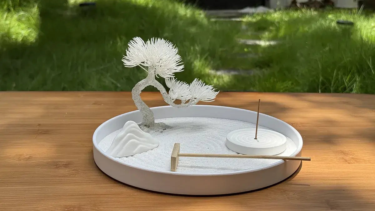 A serene Zen garden setup featuring a miniature tree, rocks, and an incense holder, illustrating 7 Zen Garden Placement Secrets and Mindfulness Practices.