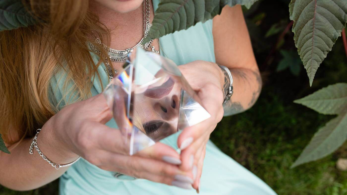 How to Choose the Right Crystal Tree Theme for You with a woman holding a crystal pyramid outdoors.