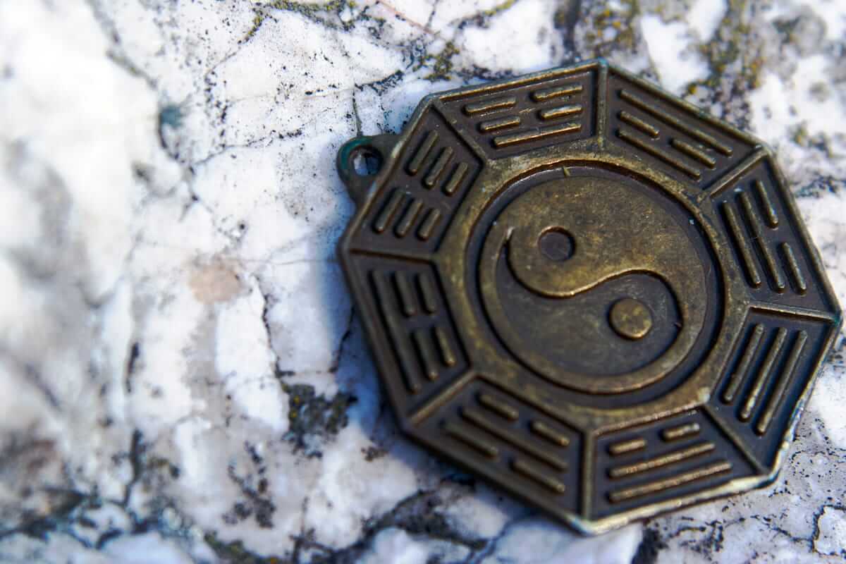 Eager to Be More Charismatic? Taoist symbol representing balance and attraction on a stone surface.