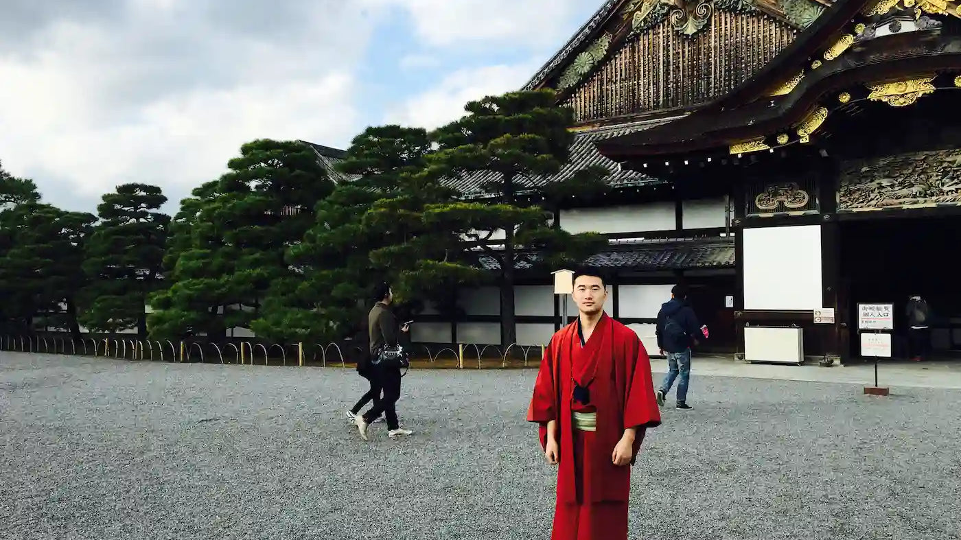Sean, founder of Zenify, visiting Kyoto Japan wearing a traditional red kimono — the trip that inspired the crystal zen garden