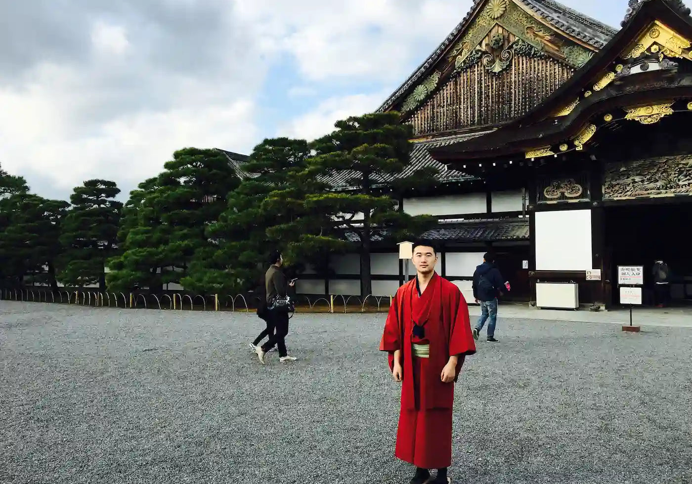 Sean, founder of Zenify, visiting Kyoto Japan wearing a traditional red kimono — the trip that inspired the crystal zen garden