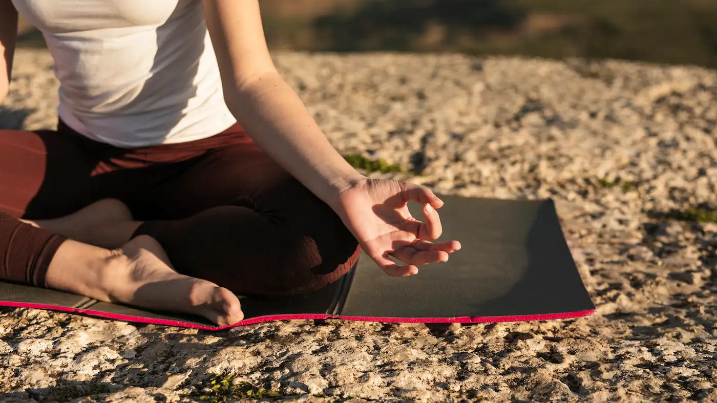 A person practicing mindfulness meditation outdoors as part of a Digital Detox Guide.