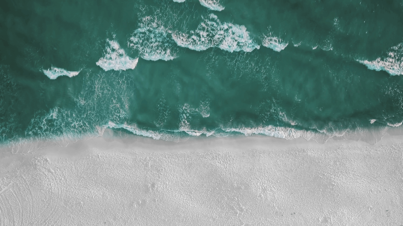 An aerial view of a serene beach, illustrating calmness and peace for Emotional Awareness Practice.