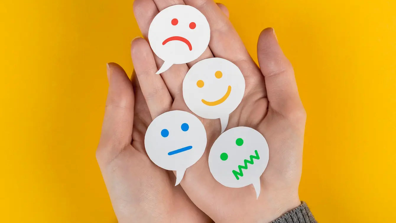 Hands holding various emotion symbols representing feelings to help make peace with the world.