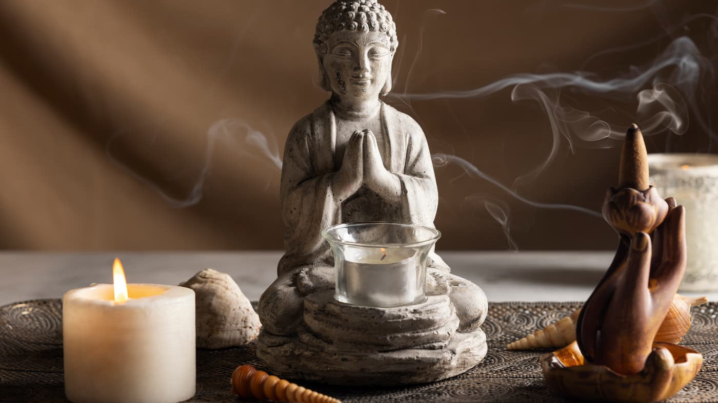 Buddhism on What Blocks Your Happiness, featuring a meditating Buddha statue and candles.
