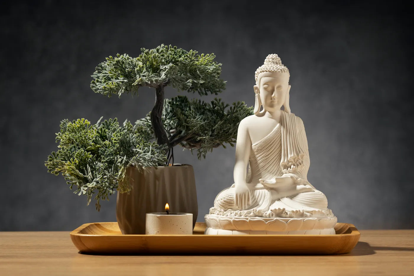 A serene Buddha statue with a small candle and a bonsai tree, representing The Reason You Can’t Meditate is the Same.