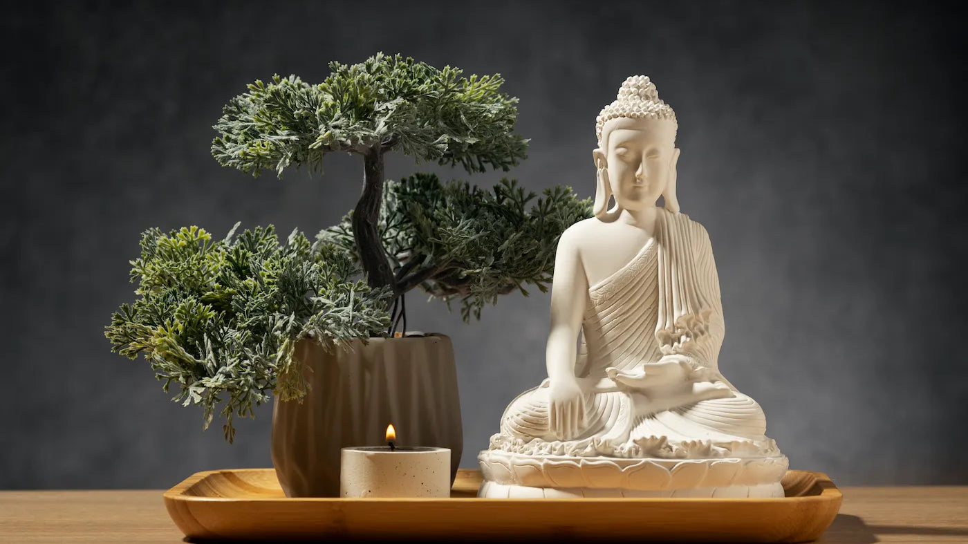 A serene Buddha statue with a small candle and a bonsai tree, representing The Reason You Can’t Meditate is the Same.