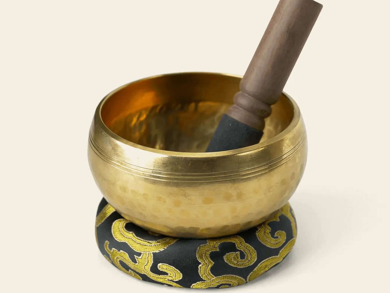 9.5 cm metal singing bowl on its cushion with the included wooden striker
