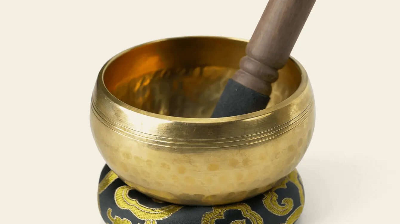 9.5 cm metal singing bowl on its cushion with the included wooden striker