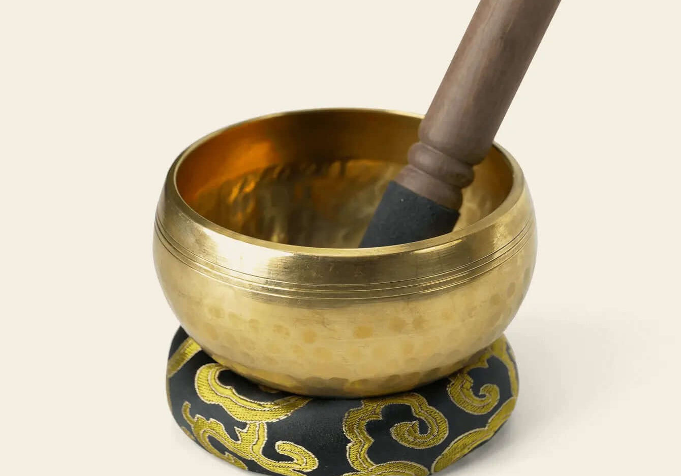 9.5 cm metal singing bowl on its cushion with the included wooden striker