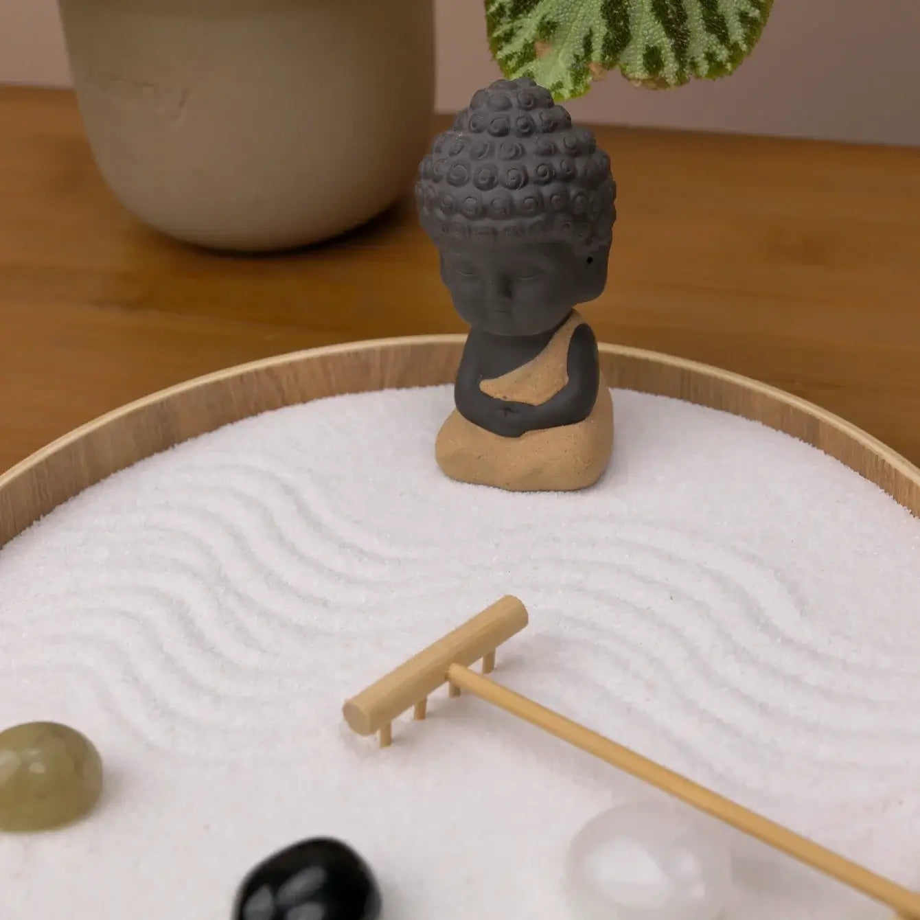 Zen Garden with a small Buddha statue and stones, promoting calm and clarity in mindfulness practice.