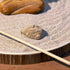 Zen Garden with a smooth stone and rake in soft sand, promoting mindfulness and relaxation at a desk.