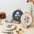 5-Hour Mindfulness Embroidery Kit displayed with flower designs in embroidery hoops and crafting supplies.