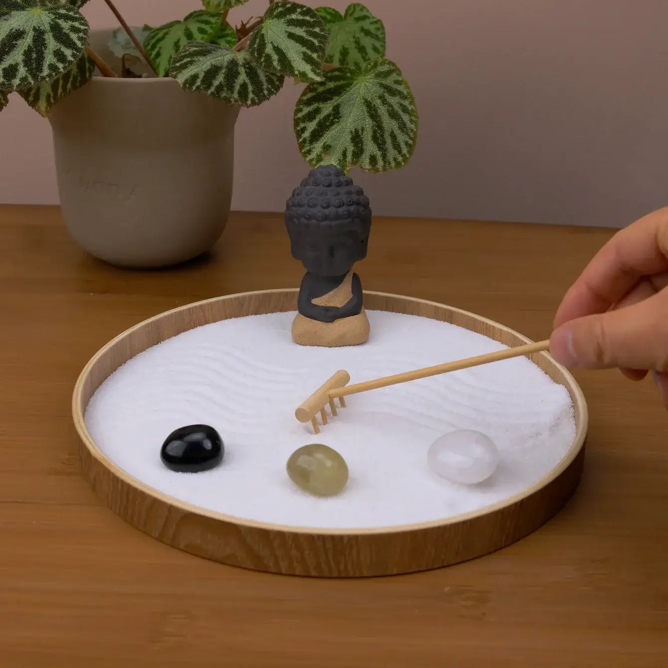 Zen Garden featuring a Buddha statue, pebbles, and a rake for mindfulness and relaxation in every moment.