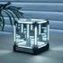 Glass cube with LED lighting on a wooden surface, featuring the 'INFINITY' brand.