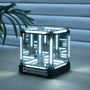 Glass cube with LED lighting on a wooden surface, featuring the 'INFINITY' brand.