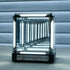 Glass container with metallic frame on a reflective surface, featuring the 'INFINITY' brand.