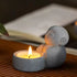 Zen-Stone Jizo Monk Cement figurine holding a small candle, creating a serene atmosphere.