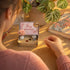 Person enjoying a Japanese Crystal Zen Garden with decorations, promoting mindfulness and tranquility.