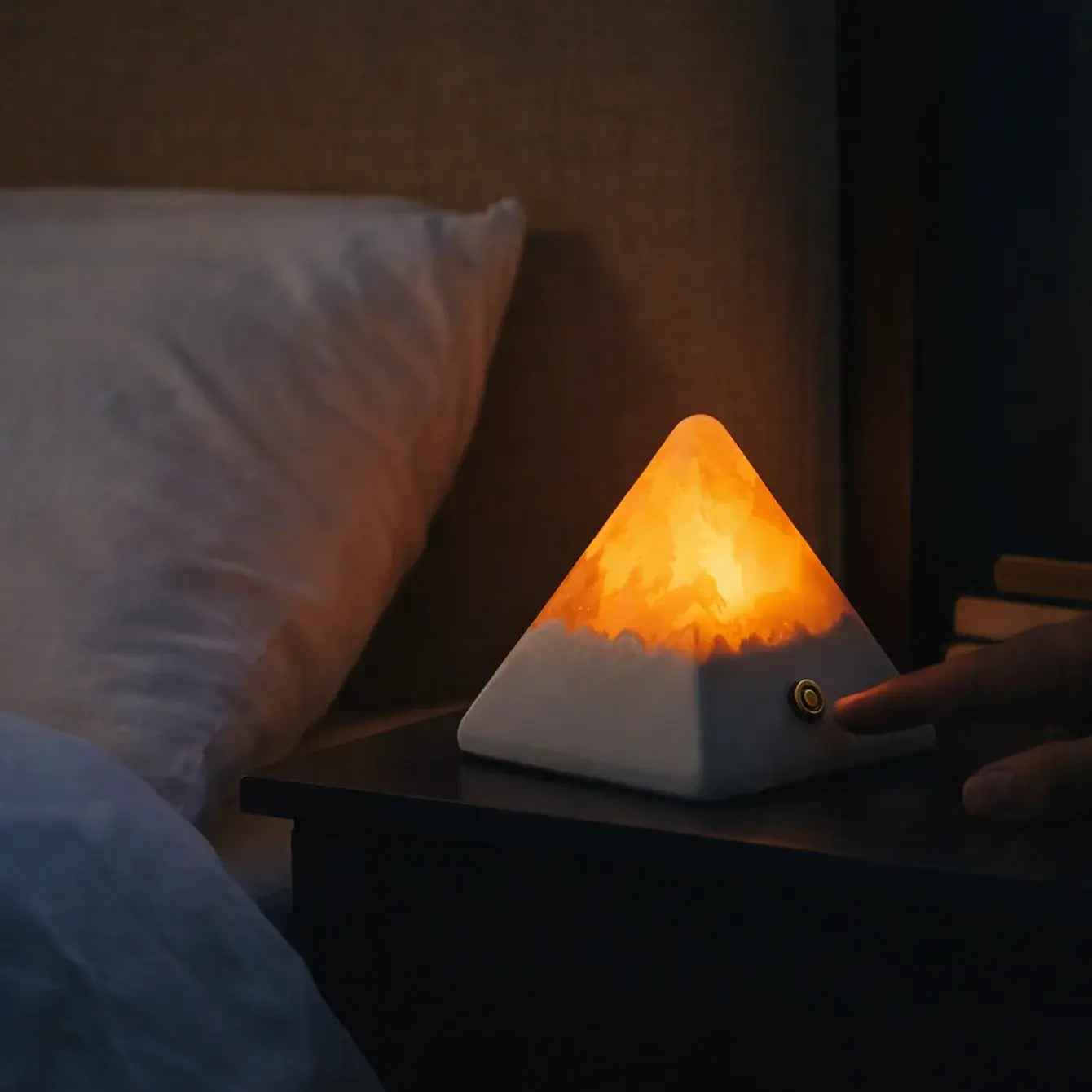 Cozy pyramid stone lamp providing a warm glow on a bedside table, enhancing relaxation in any space.