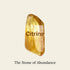 Citrine crystal, known as the stone of abundance, with a radiant yellow hue and text overlay.