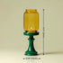 Yellow glass candle holder on a green stand with measurements indicated.
