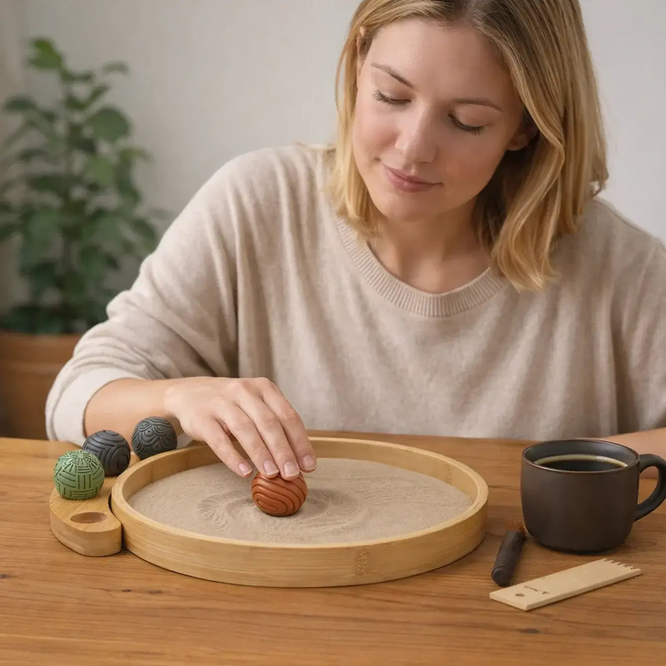 Woman enjoying a Desktop Zen Garden while interacting with textures and elements, creating a calm environment.