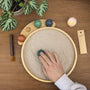 Person using a Desktop Zen Garden with bamboo sand tray and decoration stones for mindfulness and relaxation.