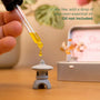 Close-up of a hand adding essential oil to a Japanese Crystal Zen Garden lantern, enhancing the meditation experience.