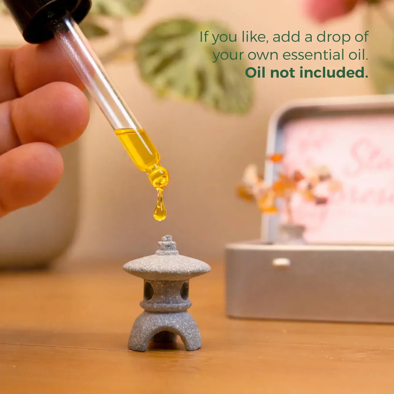 Close-up of a hand adding essential oil to a Japanese Crystal Zen Garden lantern, enhancing the meditation experience.