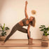 Woman practicing yoga with a Cork Yoga Block for support in a serene indoor setting.