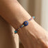 Lapis Lazuli Multi-Gemstone Woven Bracelet displayed on a wrist with deep blue centerpiece and colorful accents.
