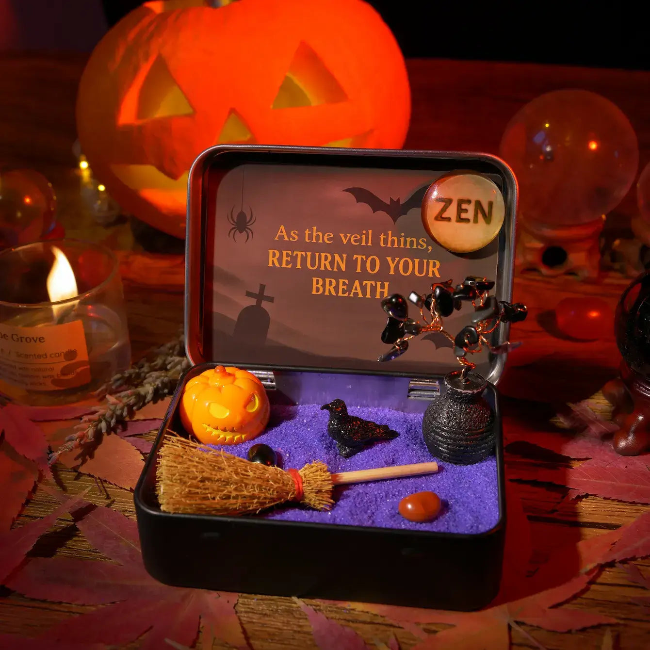 Zenify Halloween Obsidian Pocket Garden in a tin, featuring obsidian, mini pumpkins, a raven, and a broom.