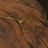 Close-up of the clasp and chain detail of Zenify™ Circle of Harmony Necklace on a wooden surface.