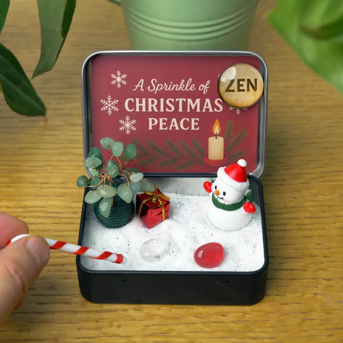 Zenify™ Christmas Zen Pocket Garden — a festive mini Zen set with a green aventurine tree, snowman, gift box, candy cane, and healing crystals on white sand.