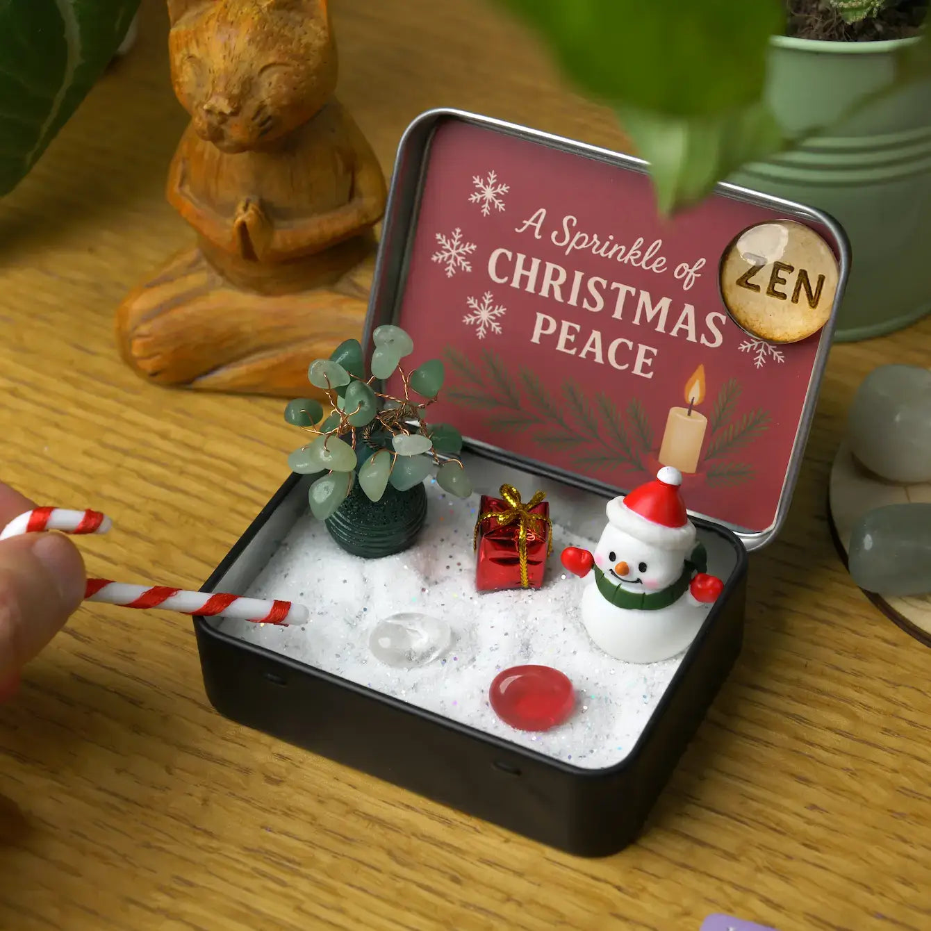Zenify™ Christmas Zen Pocket Garden — a festive mini Zen set with a green aventurine tree, snowman, gift box, candy cane, and healing crystals on white sand.