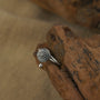 Zenify™ Silver Mantra Ring on wooden surface showcasing unique floral design and sterling silver craftsmanship.