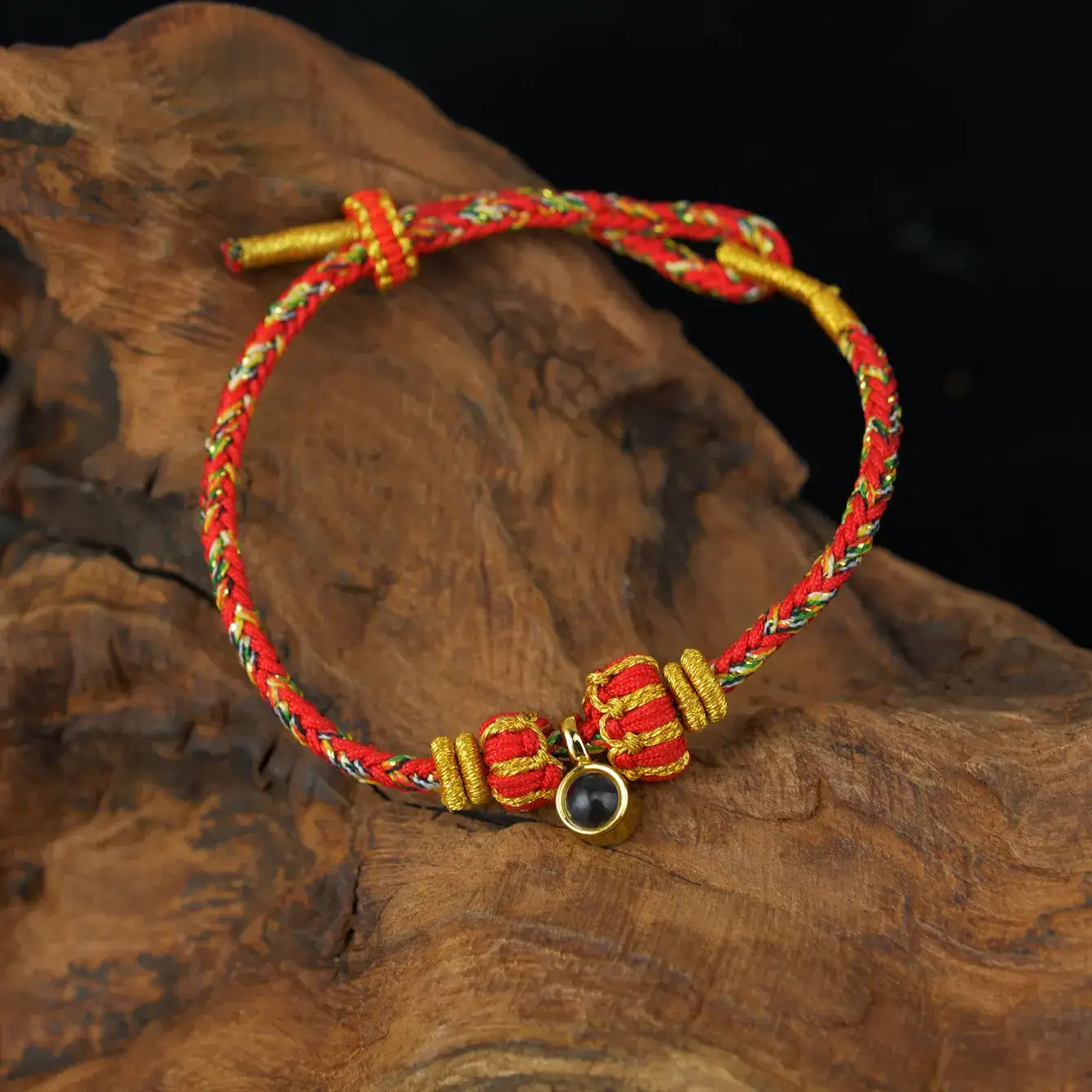 Zenify™ Sutra Light Knot – Handwoven Blessing Bracelet with red and gold detailing on a wooden surface.