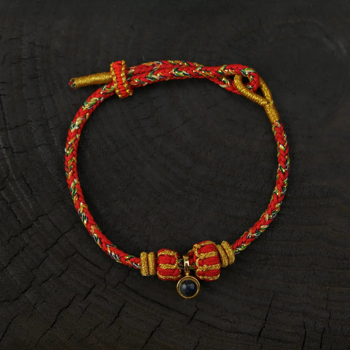 Zenify™ Sutra Light Knot – Handwoven blessing bracelet with red and gold threads and a black gemstone charm.