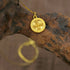 Gold plated dual blessings necklace pendant featuring Lotus and Vajra design on textured surface.