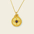 Circle of Harmony Necklace featuring a gold pendant with a central gemstone and intricate engravings.