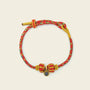 Zenify™ Sutra Light Knot – Handwoven red and yellow blessing bracelet with sacred knot design.