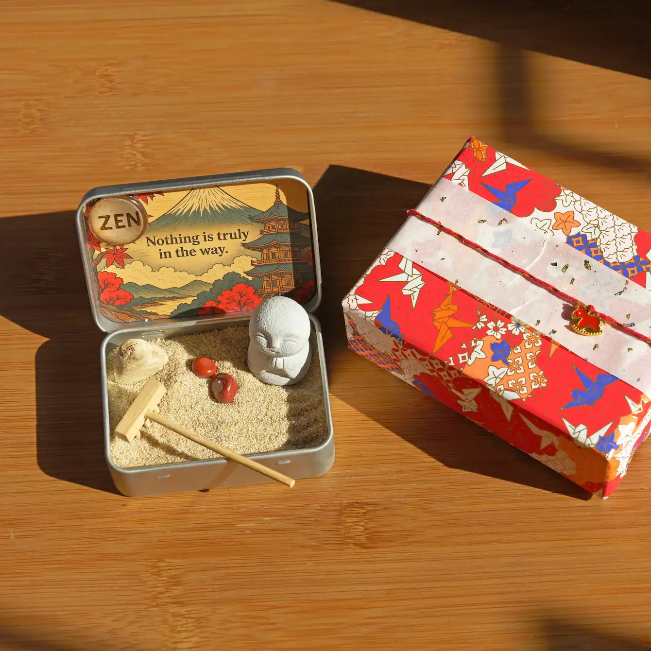 Red Leaf Zen Garden kit components with warm sand, Jizo figure, red maple leaves, and red jasper stones.