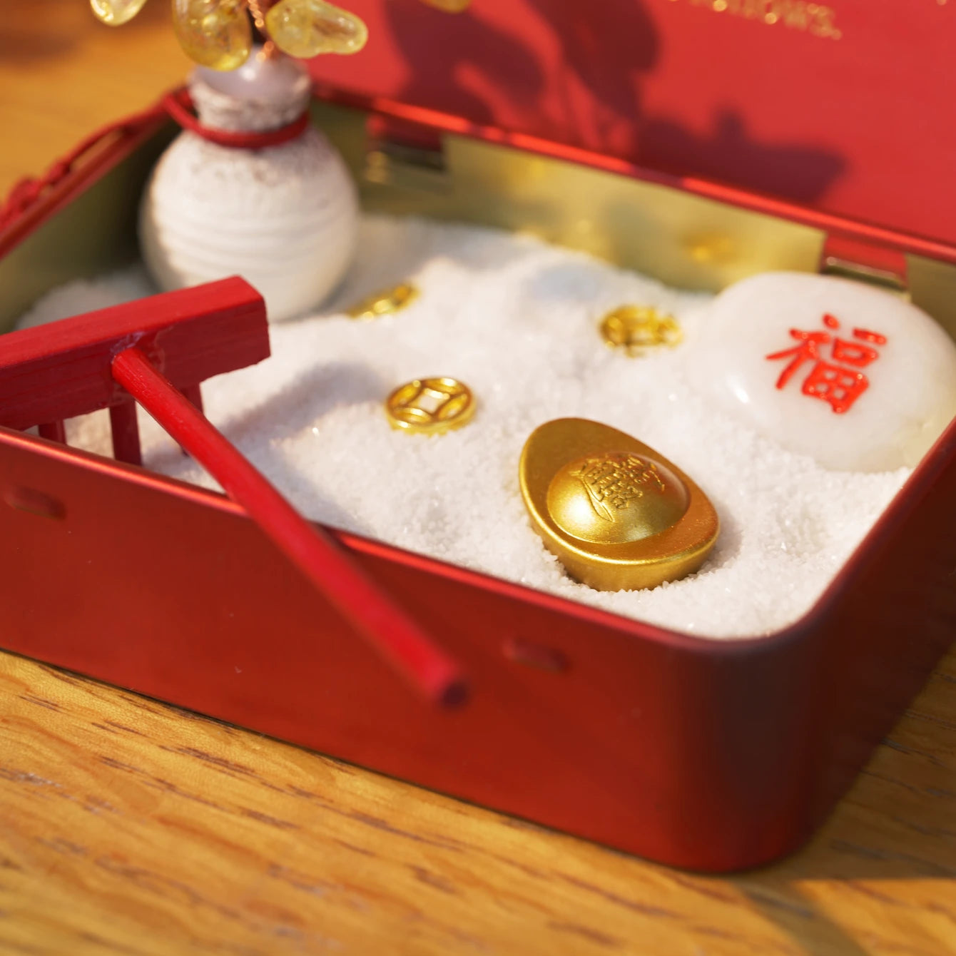 New Year Crystal Zen Garden featuring golden coins, a rake, and a crystal tree in white sand.