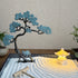 Copper blue pine tree and glowing resin stone lantern arranged in raked fine white sand